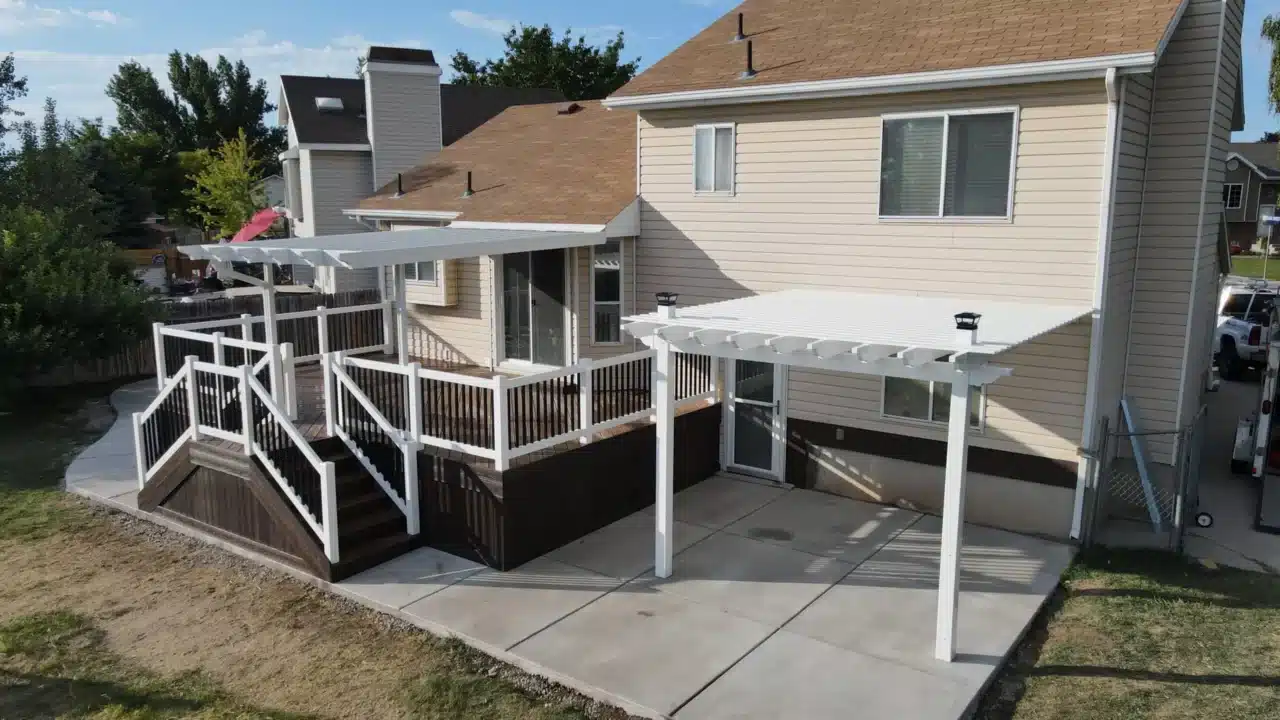 custom deck and concrete patio with a multi-level pergola design