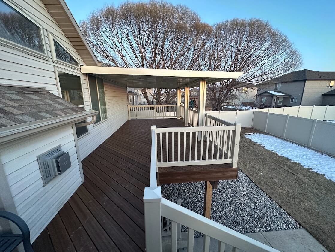 photo of a deck in the off-season with a covered deck area and deck railing - Deck Builders in Utah