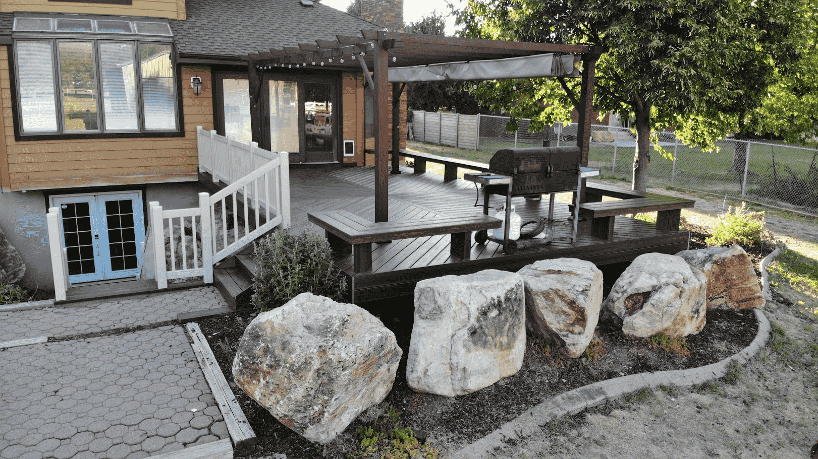 photo of a deck with built-in benches and a pergola