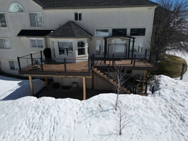 photo of elevated deck with deck railing and pergola - Building a deck on winter in Utah